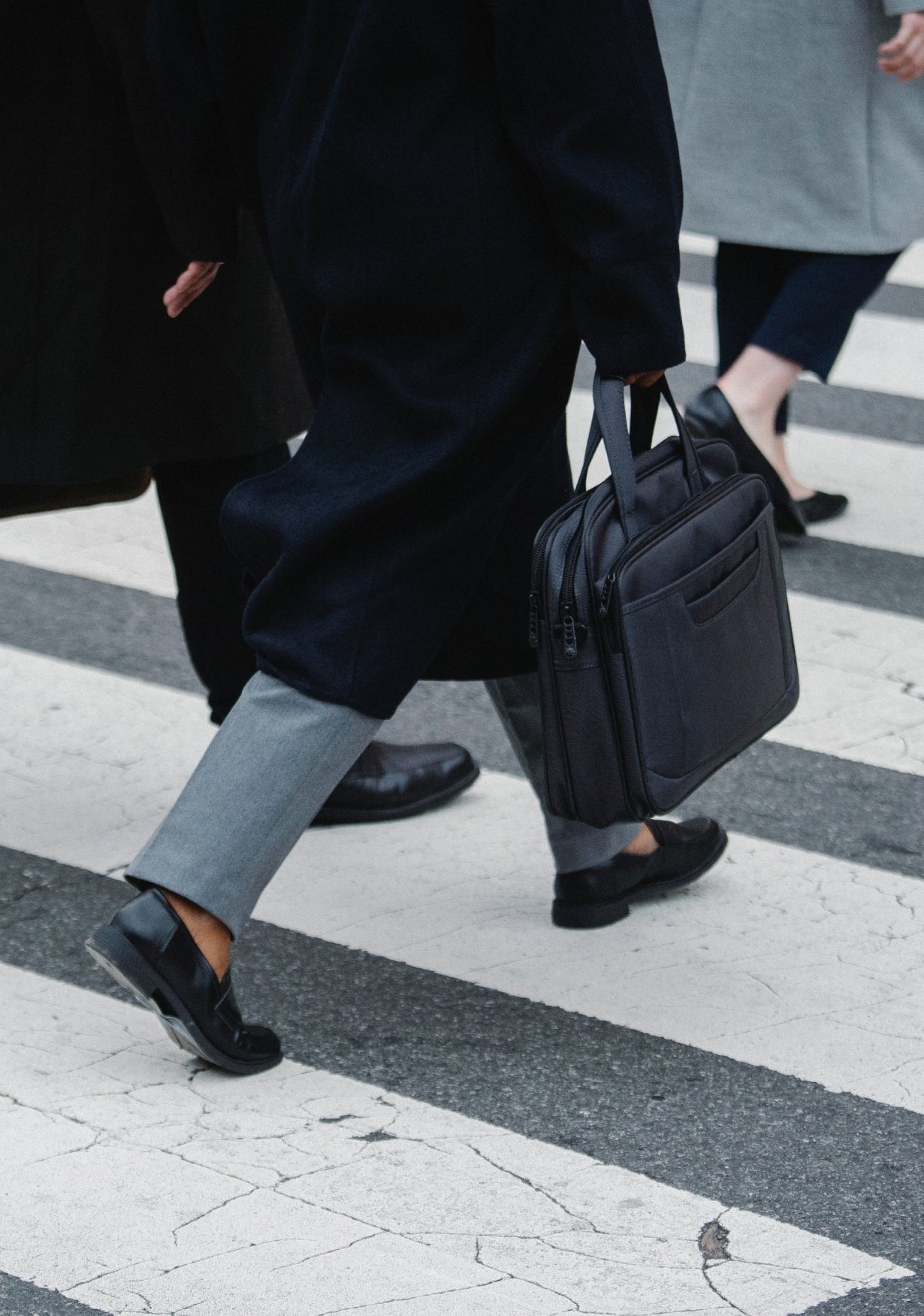 Passants en costume traversant un passage piéton