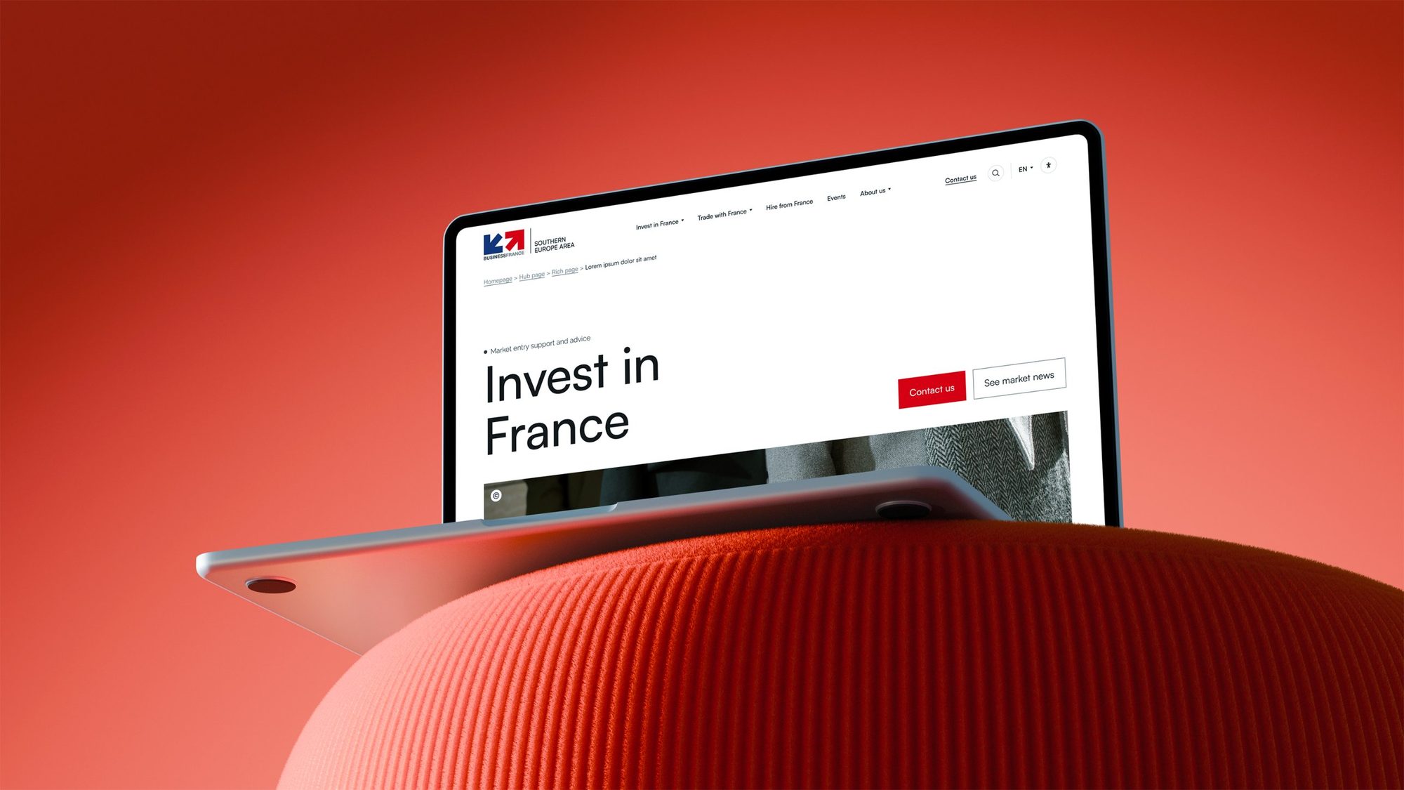 Page Invest in France sur un ordinateur posé sur un pouf rouge