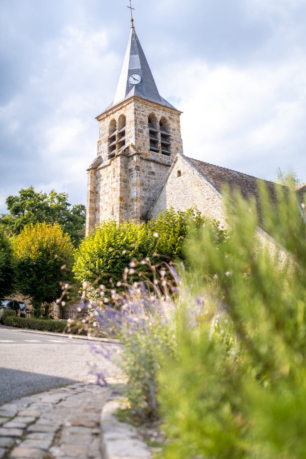 Clocher d’une église de village entouré de fleurs